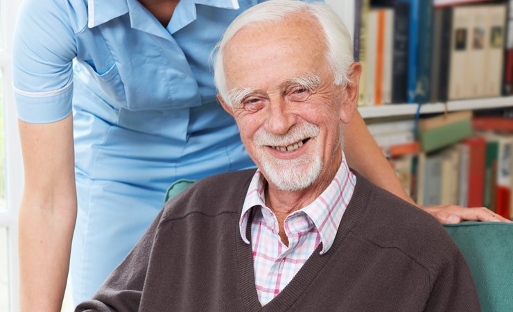 Sundhedsmedhjælper server med til en ældre mand
